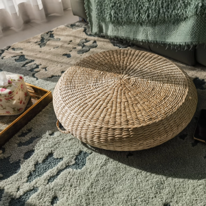 Close-up of handwoven bulrush cushion, showing natural fiber weave and carrying handle