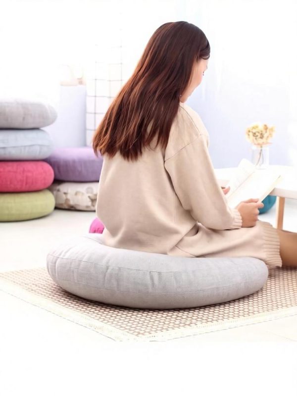 Multiple colors linen floor cushions, lady sitting and reading on cushion
