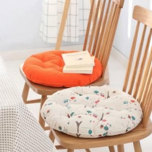 Patterned and solid color tufted cushions placed on solid wood dining chairs for home and hotel canteen seating upgrade