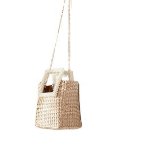Beige straw tote bag with pearl handle and gold chain on white background